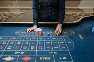 Casino dealer arranging chips on a roulette table in an elegant setting. Perfect for gaming content.